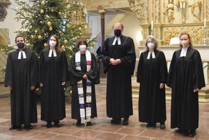 Sechs Menschen in geistlicher Kleidung mit Atemschutz